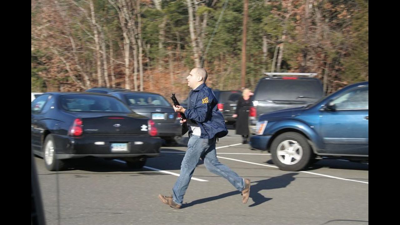 A Connecticut State Police officer runs with a shotgun at the Sandy Hook Elementary School in Newtown on December 14.