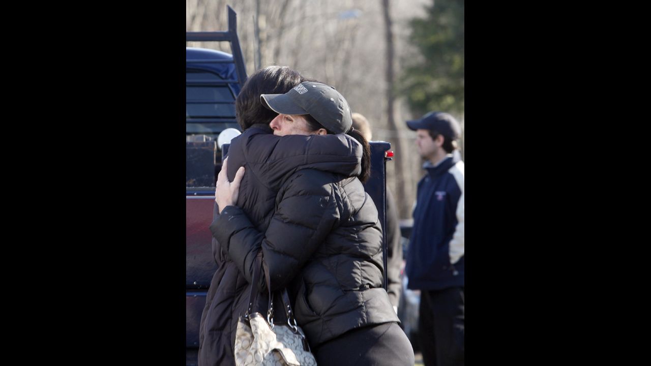 People embrace outside Sandy Hook Elementary School on December 14.