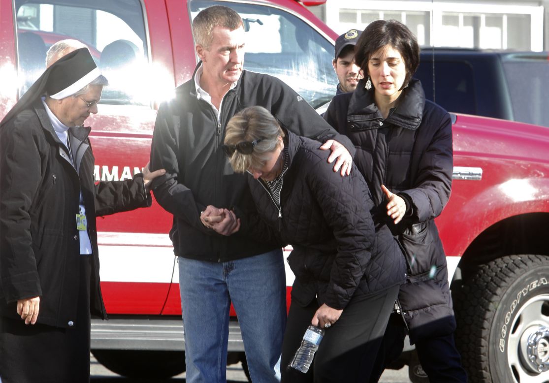 People try to deal with the shock of the attack outside Sandy Hook Elementary School on December 14.