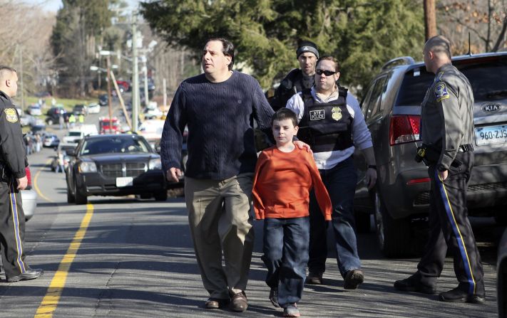 A man escorts his son away from Sandy Hook Elementary School on December 14.