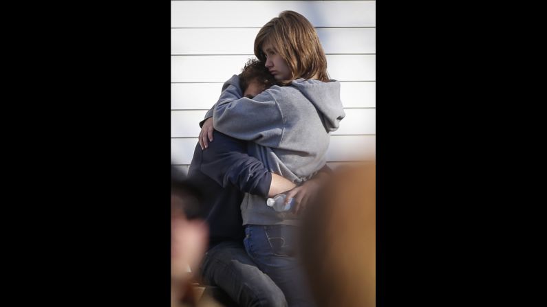 People comfort each other near Sandy Hook Elementary School on December 14.