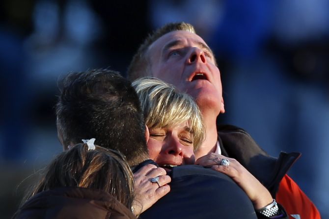 People weep and embrace near Sandy Hook Elementary School on Friday, December 14.