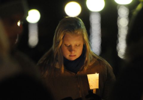Corinne McLaughlin, a student at the University of Hartford, bows her head during a candlelight vigil at Hartford, Connecticut's Bushnell Park on Friday, December 14, honoring the students and teachers who died at Sandy Hook Elementary School in nearby Newtown earlier in the day.