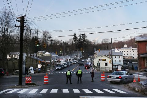 Police officers stand at the entrance to the street leading to the Sandy Hook Elementary School on December 15.