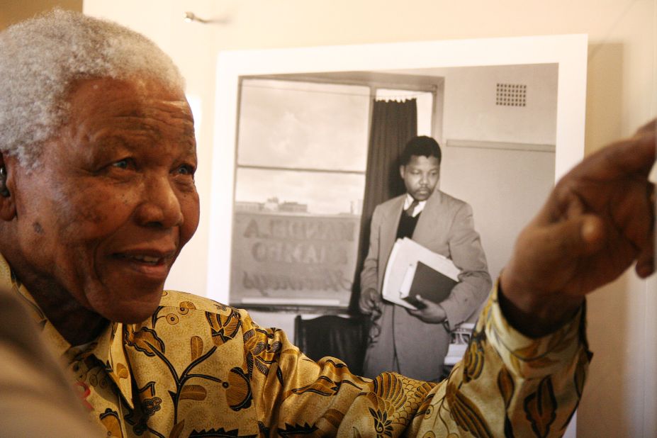 Mandela shows something to a group of international journalists visiting the Nelson Mandela Foundation in Johannesburg in May 2004.