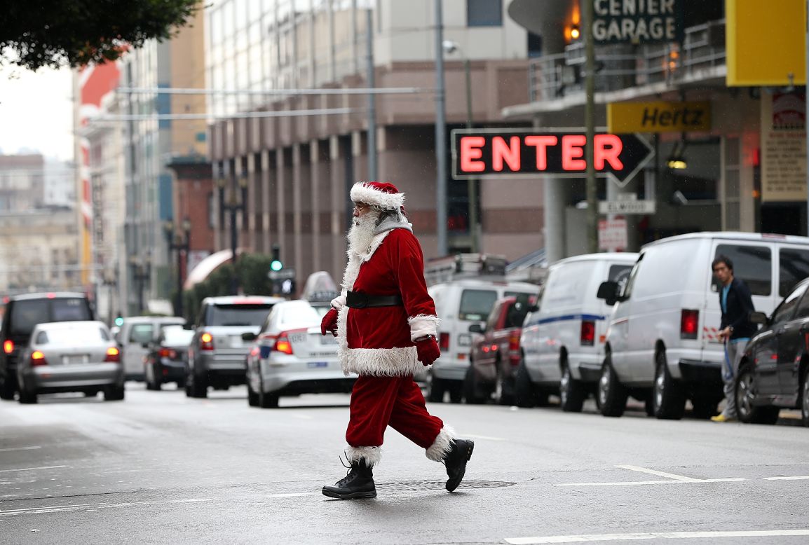 A man decked out as Santa walks down Geary Street on December 14 in San Francisco.