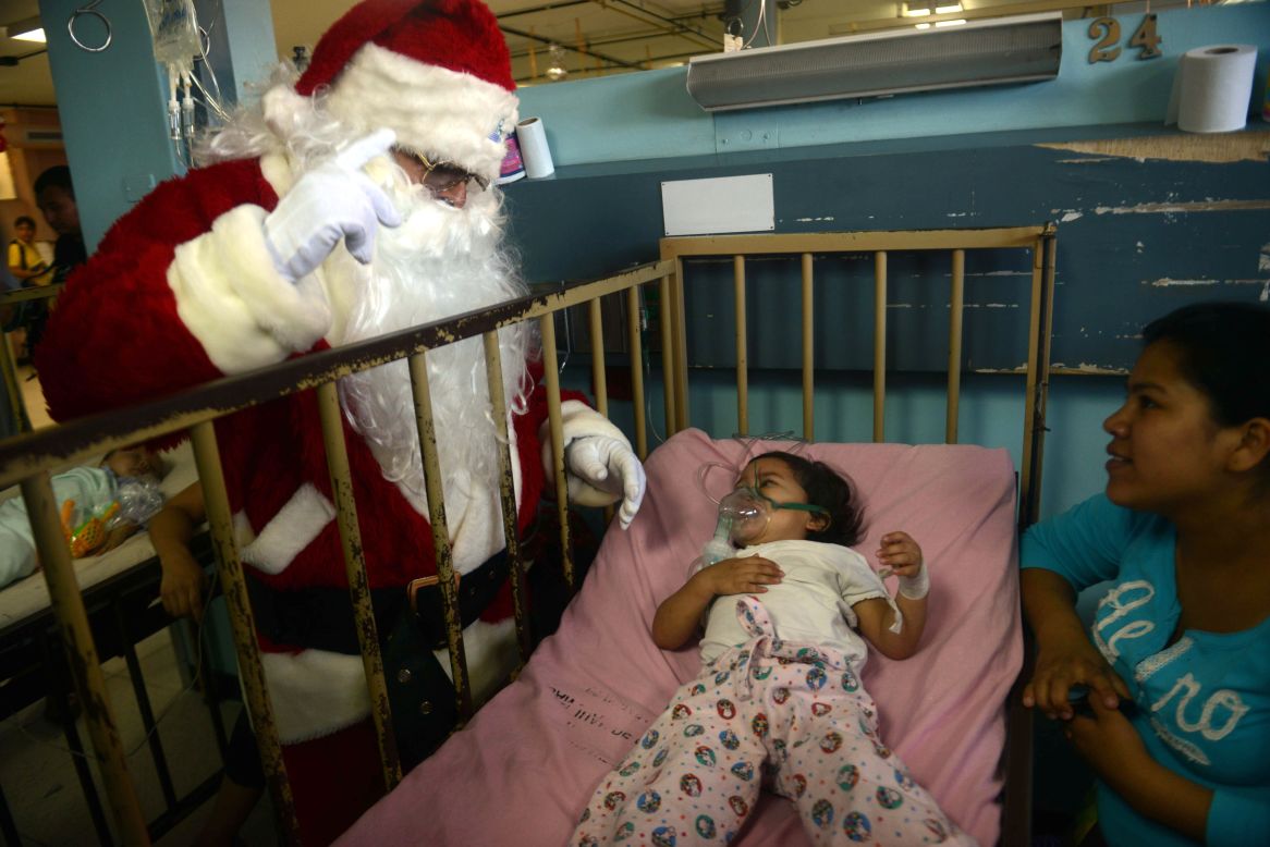 A man dressed as Santa Claus sees a patient in the pediatric ward of a hospital in Guatemala City, Guatemala, on Friday, December 14. 
