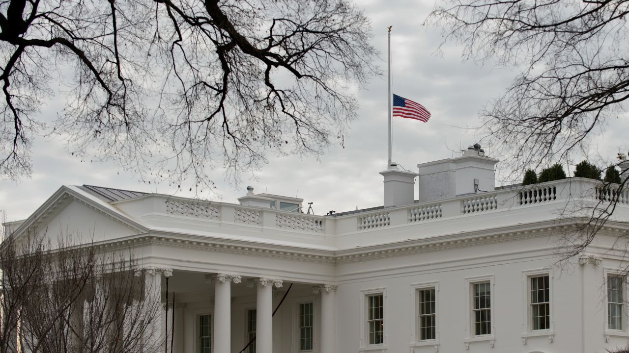 The U.S. flag flies at half-staff above the White House on Saturday.