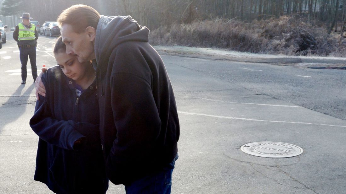 Ken Kowalsky and his daughter Rebecca, 13, embrace while standing at the end of the road leading to Sandy Hook Elementary School on Saturday.