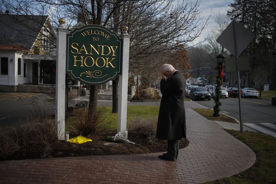 New Jersey resident Steve Wruble, who was moved to drive out to Connecticut to support local residents, grieves for victims at the entrance to Sandy Hook village in Newtown on Saturday.