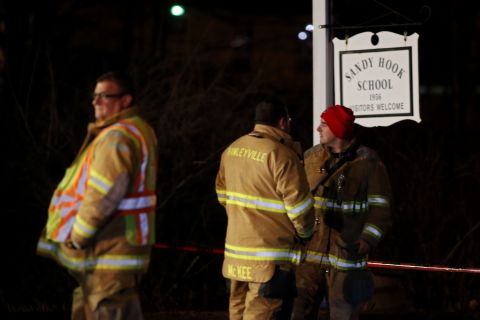 Emergency workers stand in front of the Sandy Hook Elementary School in Newtown.