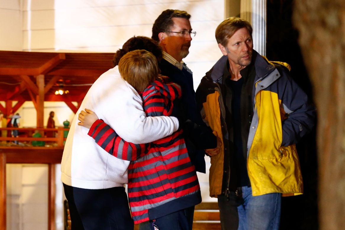 People hug outside of the Newtown United Methodist Church on Friday, near the site of the shootings at the Sandy Hook school.