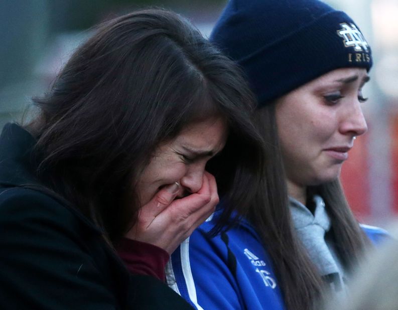 People are overcome with emotion Saturday at a makeshift memorial near Sandy Hook Elementary School in Newtown.