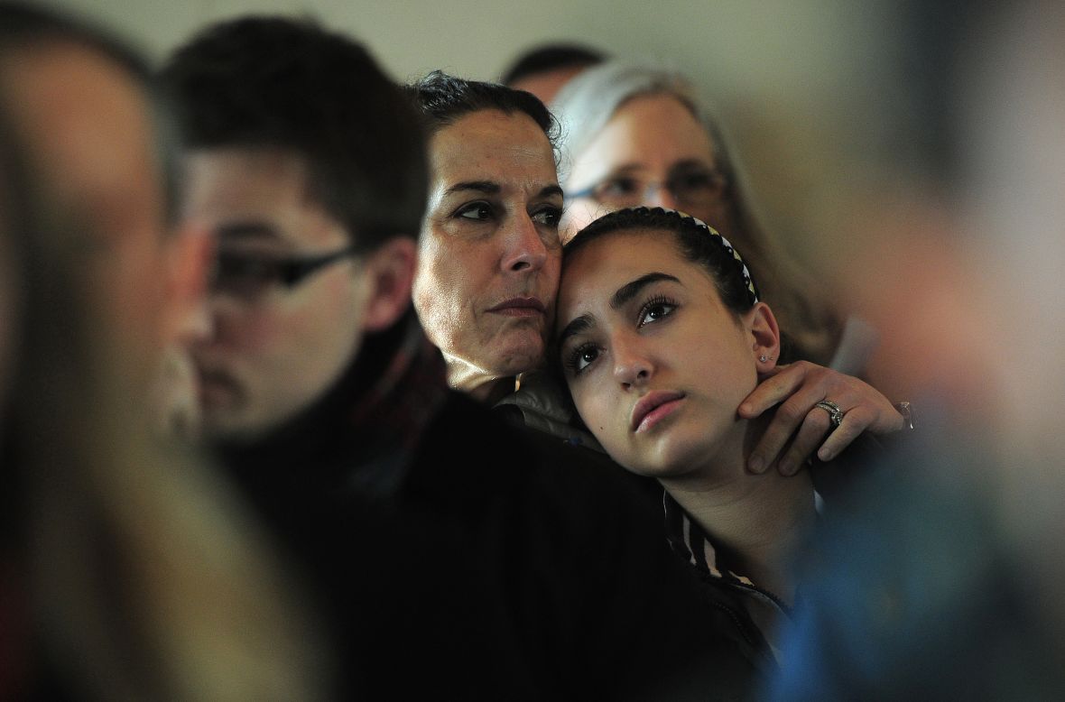 A mother and daughter attend a prayer service at St. John's Episcopal Church in Newtown on Saturday.