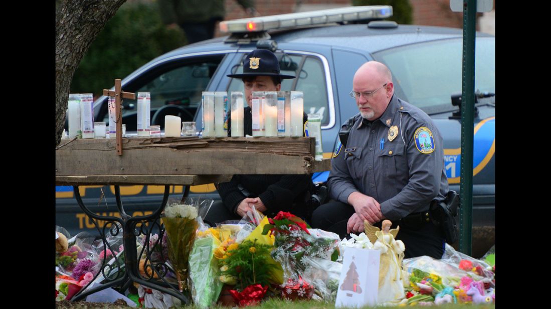 Police officers honor the victims of the school shooting at the St. Rose of Lima Roman Catholic Church on December 16 in Newtown.