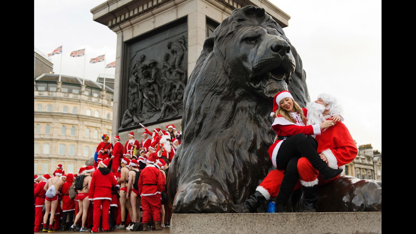 Revelers in Santa costumes sit on the lion statue at the base of Nelson's Column in London's Trafalgar Square on December 15.