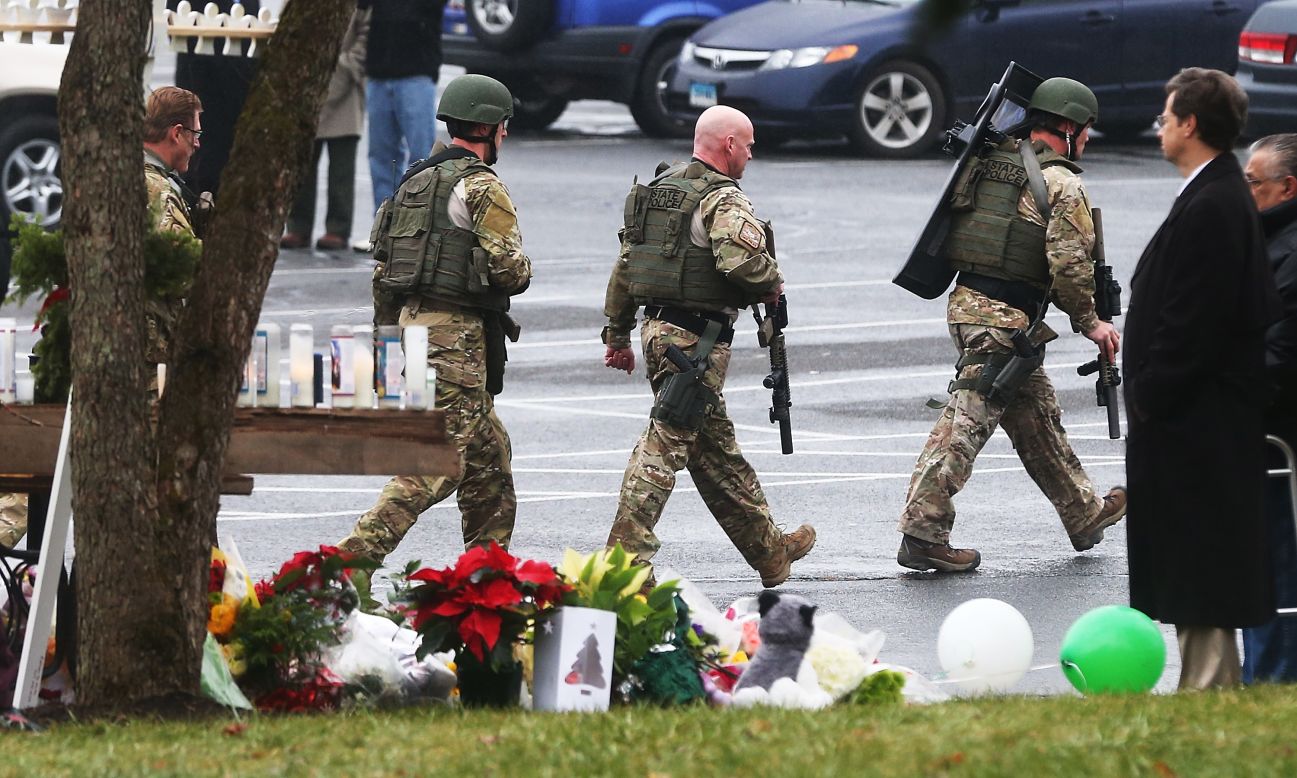 Connecticut State Police officers search outside St. Rose of Lima Roman Catholic Church in Newtown, Connecticut, on Tuesday, December 16, after a threat prompted authorities to evacuate the building. Investigators found nothing to substantiate the reported threat, a police official said, declining to provide additional details. The church held Sunday services following the mass shooting at Sandy Hook Elementary School in Newtown.