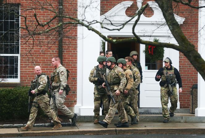 Connecticut State Police officers walk out of St. Rose of Lima Roman Catholic Church after the Newtown church received a threat December 16.