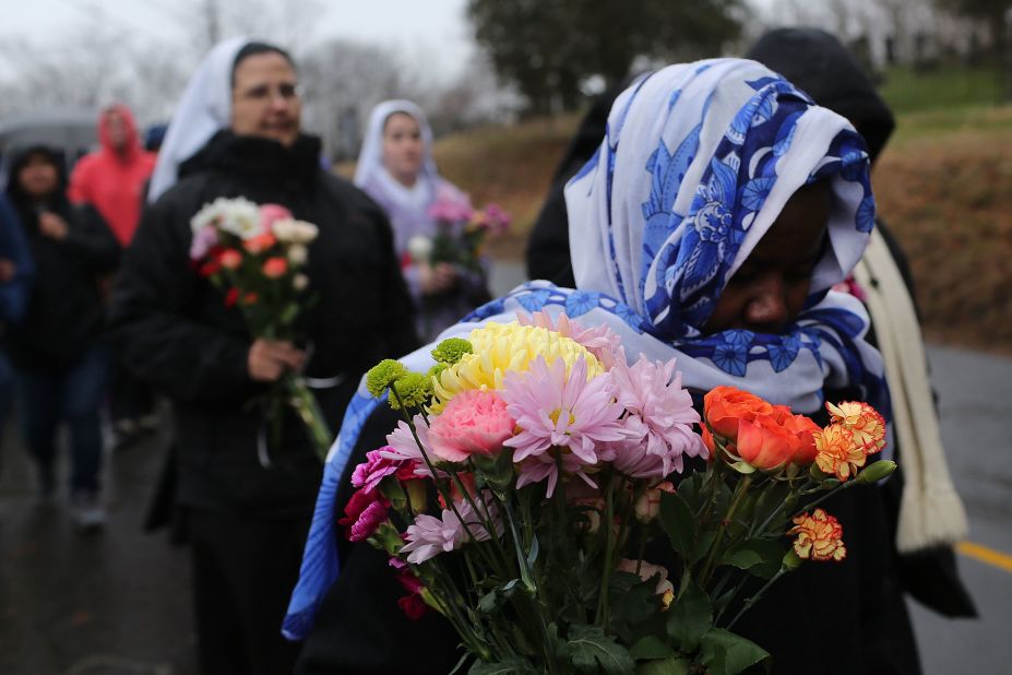 Members of Sisters of Christian Charity go to lay flowers in front of the Sandy Hook Elementary School on December 16 in Newtown.