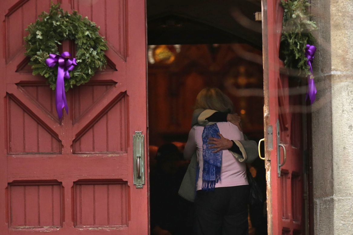 A woman receives a hug as she leaves morning service December 16 at Trinity Church in Newtown near the elementary school.