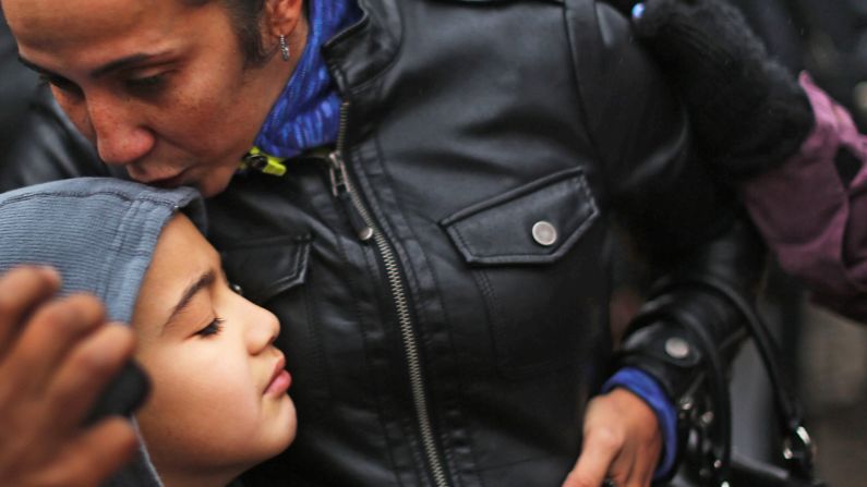 Ty Diaz is kissed by his mother, Yvette, at a memorial down the street from Sandy Hook on December 16.