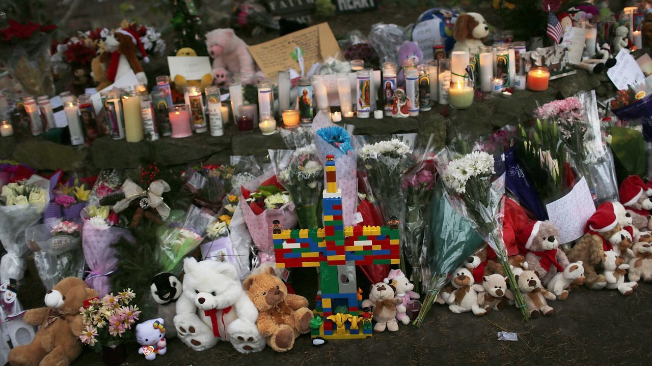 Teddy bears, flowers and candles in memory of those killed are left at a memorial down the street from the school on December 16.