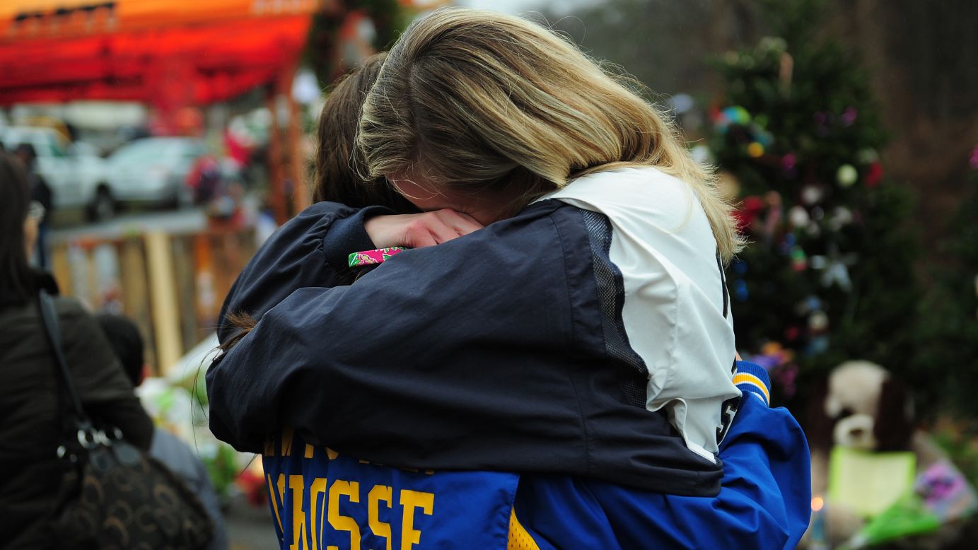 Two teenagers embrace at a makeshift shrine to the victims in Newtown on December 16.