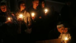 Left to right: Newtown residents Claire Swanson, Kate Suba, Jaden Albrecht, Simran Chand and New London, Connecticut residents Rachel Pullen and her son Landon DeCecco, hold candles at a memorial for victims on the first Sunday following the mass shooting at Sandy Hook Elementary School on December 16 in Newtown, Connecticut.