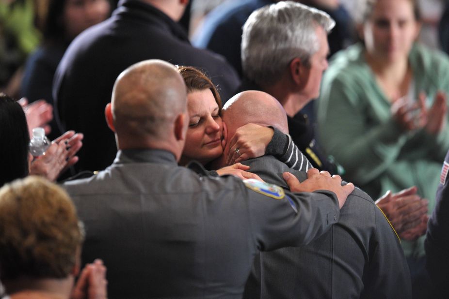 A woman comforts a law enforcement officer at Sunday night's interfaith prayer vigil. 