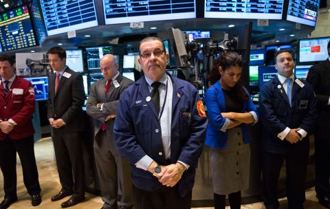 Traders on the floor of the New York Stock Exchange hold a moment of silence on December 17 in honor of the shooting victims.