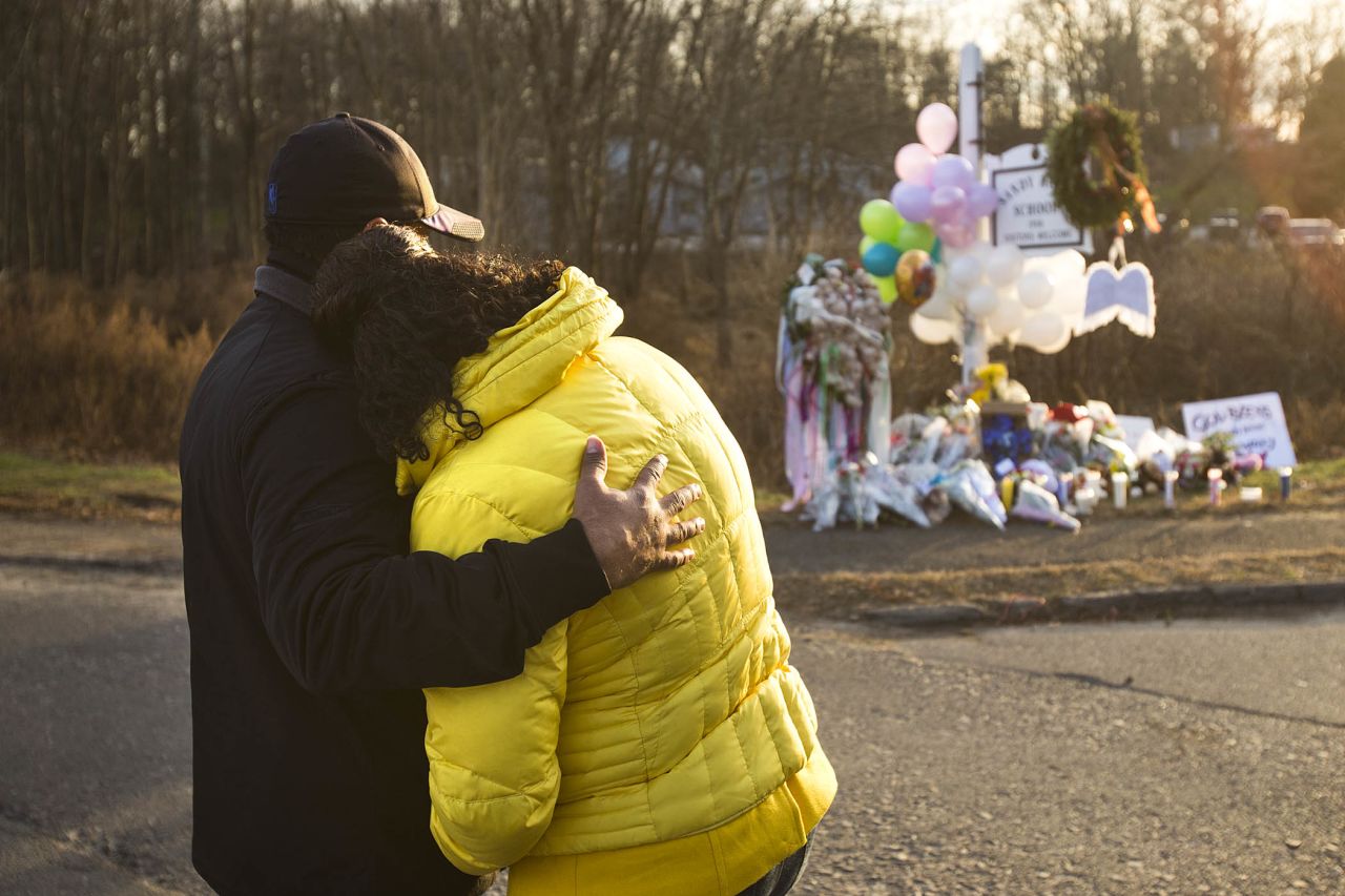 Two people embrace near a makeshift memorial in Newtown, Connecticut, on Saturday, December 15.