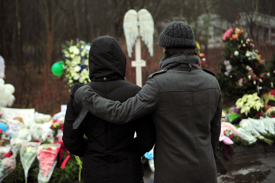 People pay their respects on Monday, December 17, at a memorial to the victims of an elementary school shooting in Newtown, Connecticut.