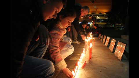 Albanian children light candles as pay their respects to the victims of a elementary school shooting in Newtown, Connecticut.