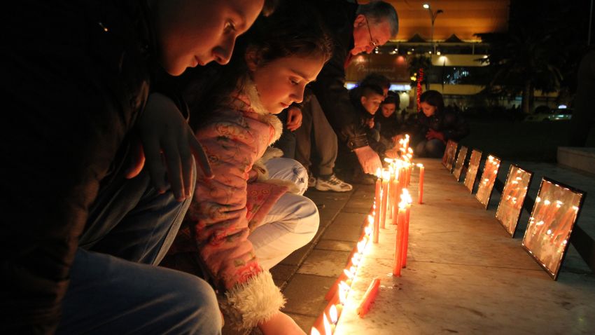 Albanian children light candles as pay their respects at Tirana's main square on December 17, 2012, to the victims of a elementary school shooting in Newtown, Connecticut.