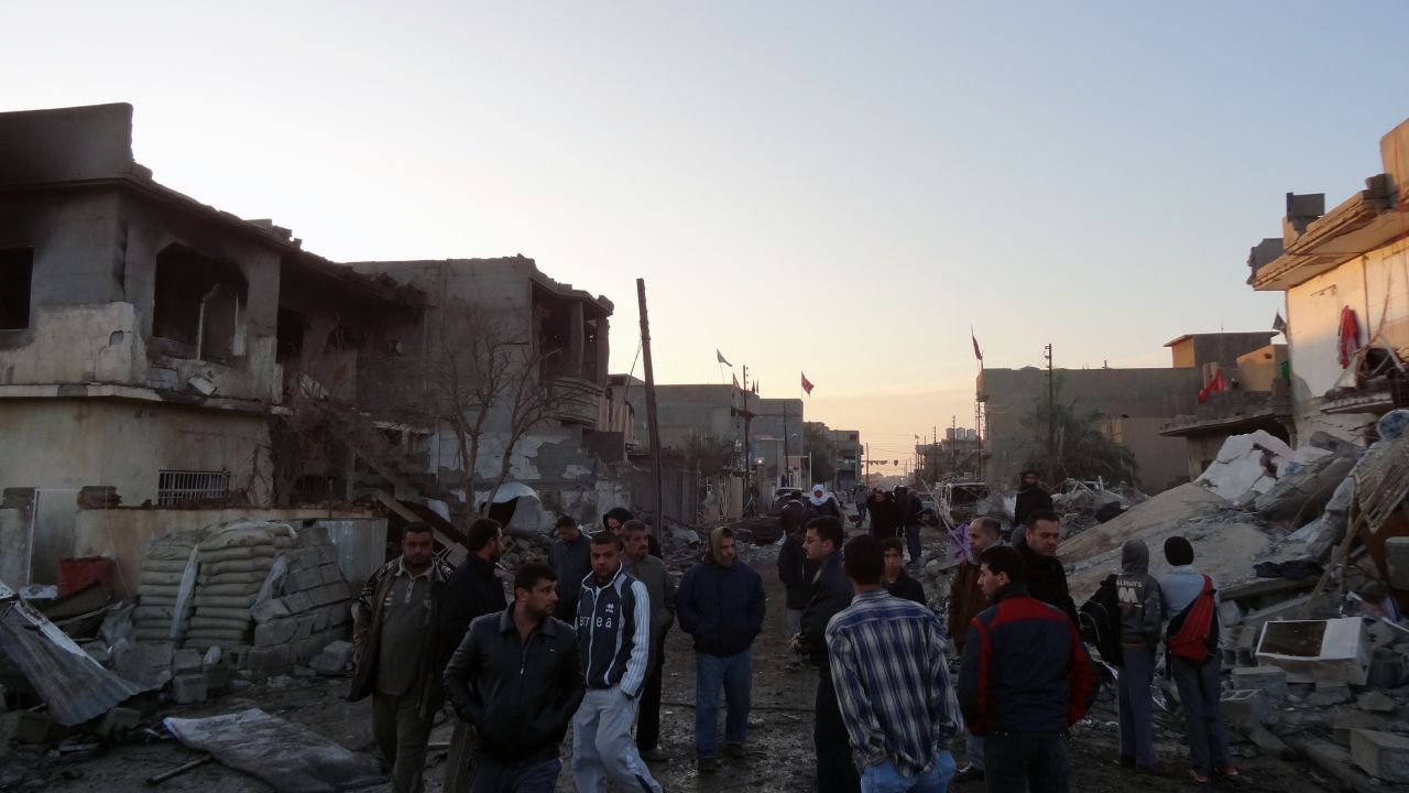 Iraqis inspect damage after two bomb blasts in the town of Tuz Khurmato in Kirkuk province Monday. 