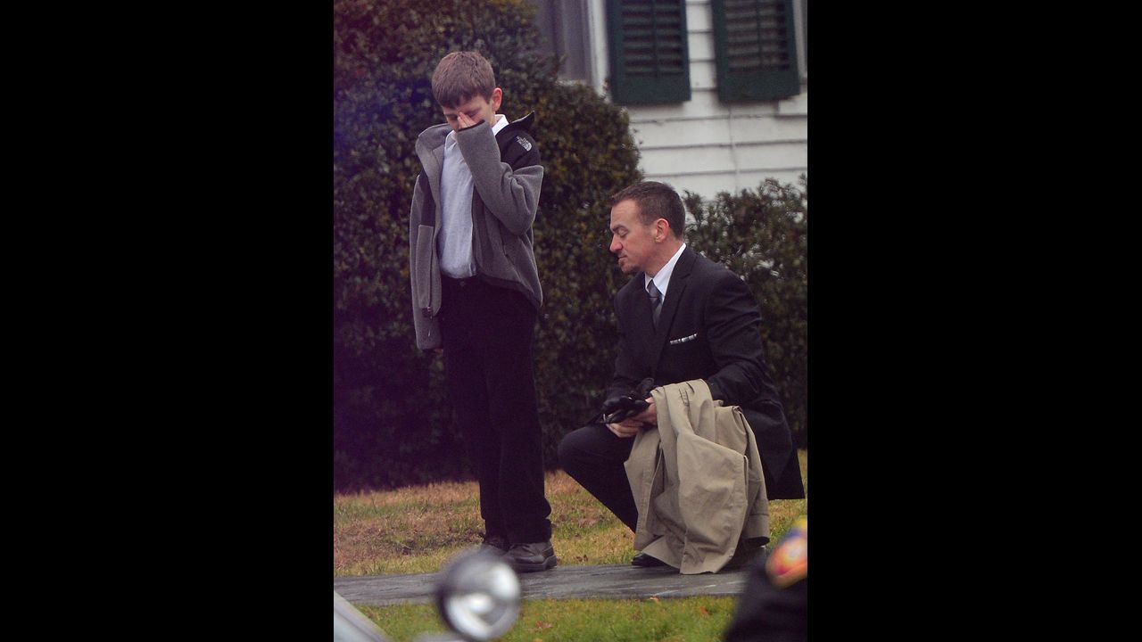 A man comforts a young mourner at Honan Funeral Home while attending the funeral for Jack Pinto, 6, on December 17.