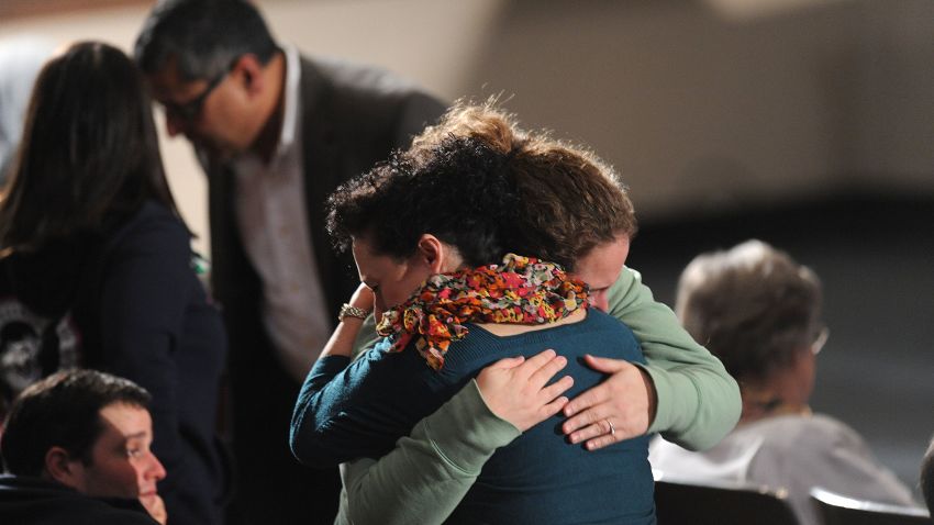 Mourners comfort one another at an interfaith vigil for the shooting victims on December 16.