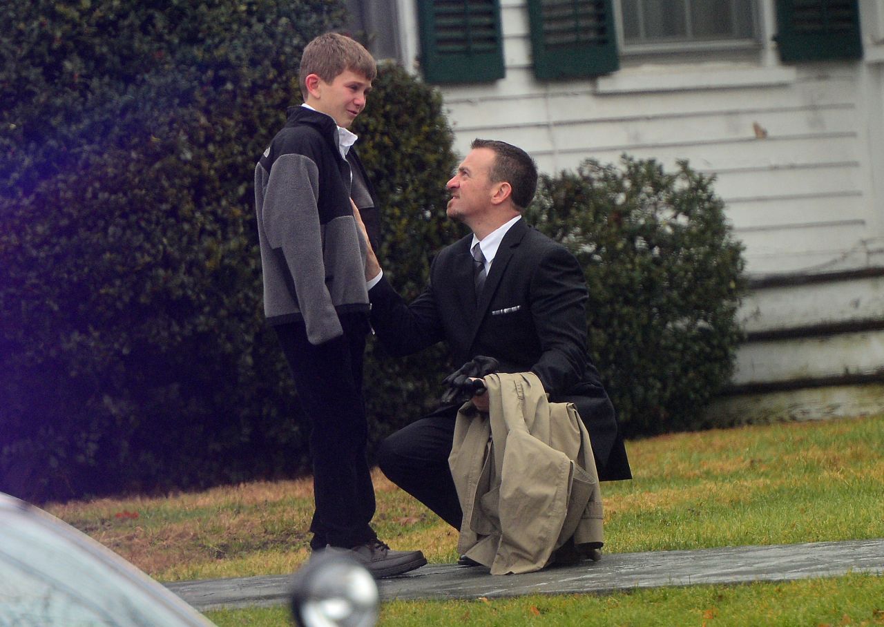 A man comforts a young boy after the funeral for Jack Pinto, 6, one of the children killed when Adam Lanza stormed their elementary school and claimed the lives of 20 children and six adults after killing his mother. Lanza turned the gun on himself as police closed in.