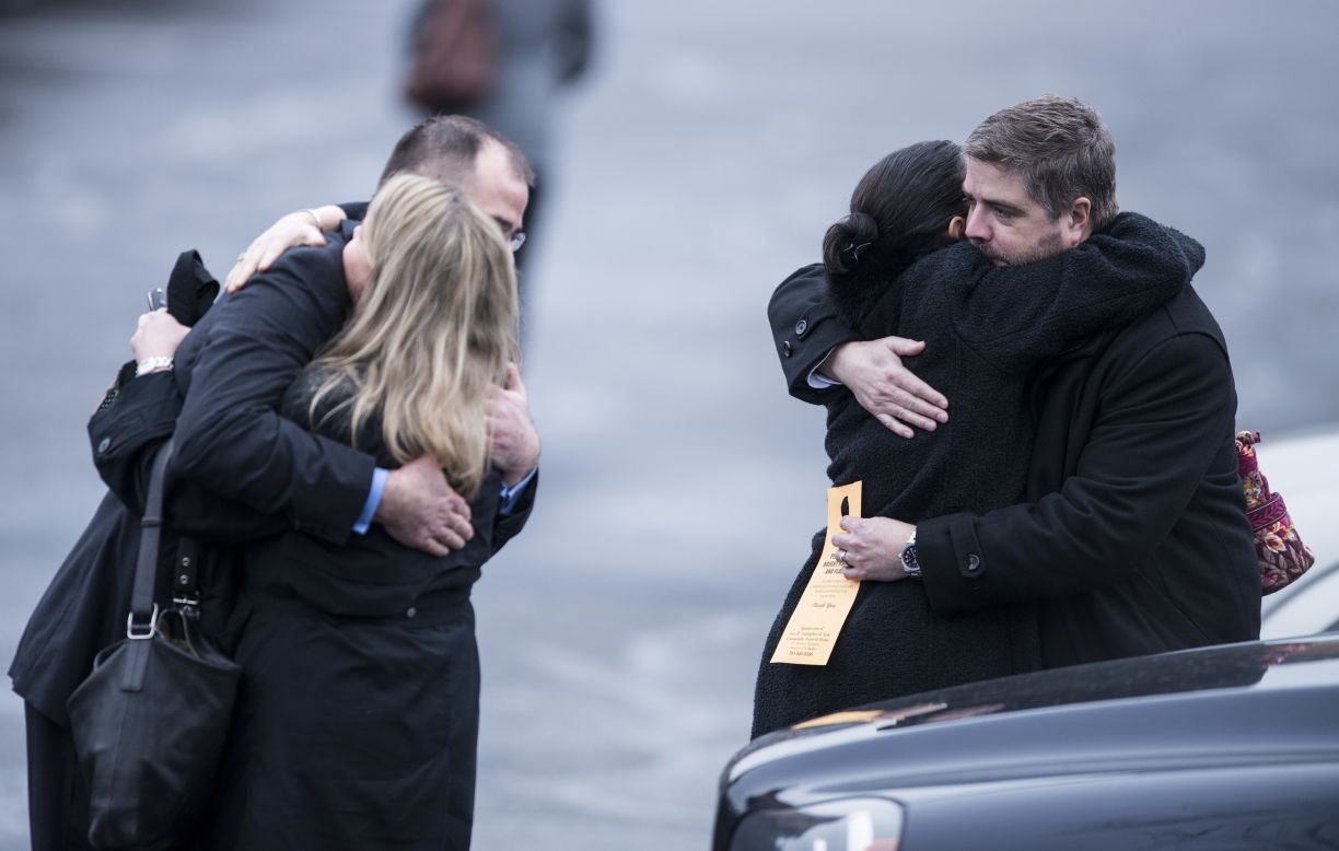 Mourners console each other after the funeral for James Mattioli on December 18.