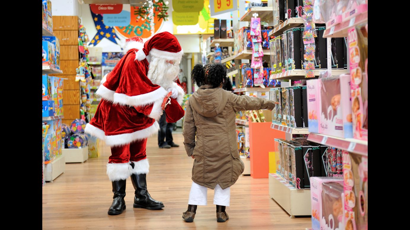 A girl points out toys to Santa Claus on Saturday, December 15, in a store in Lille, France. 