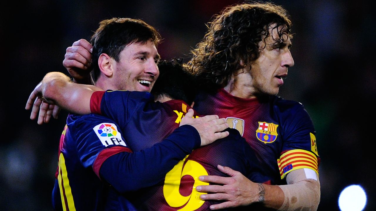 Lionel Messi receives the congratulations of Xavi (hidden) and Carles Puyol (right) after scoring against Real Betis on December 9, the goal that broke Gerd Mueller's 40-year record.  