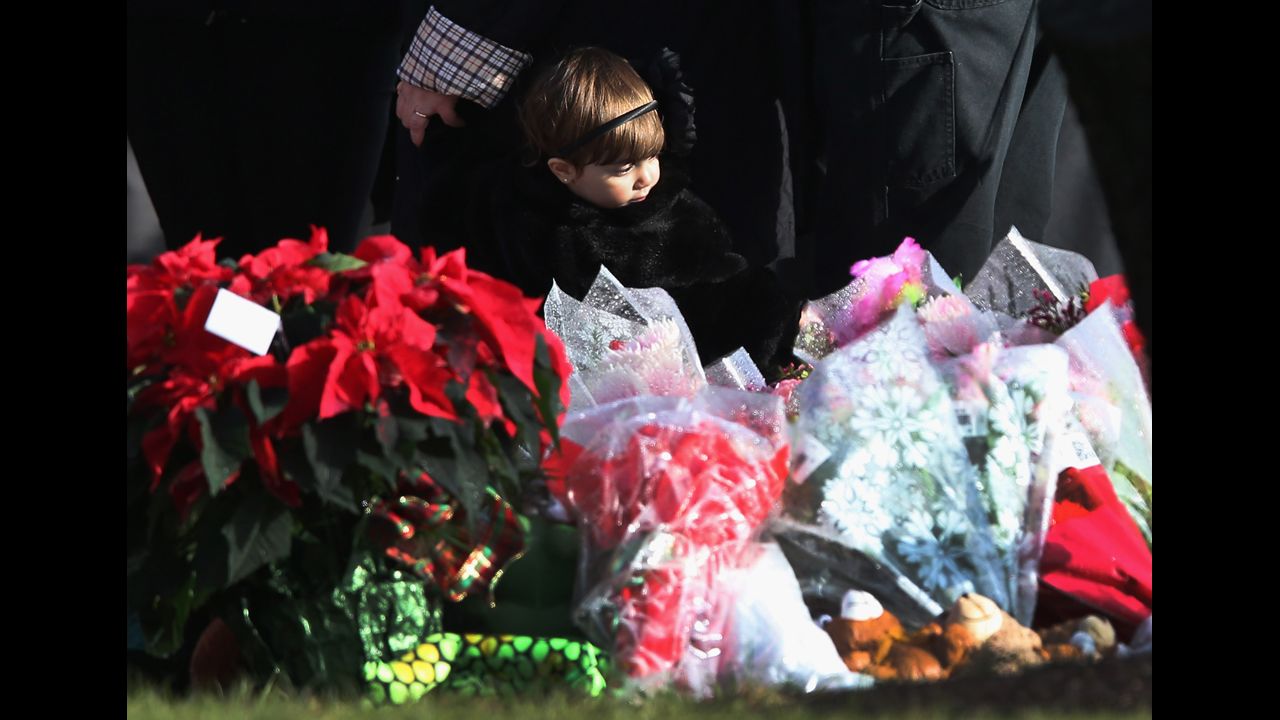 A child stands next to a makeshift memorial for Jessica Rekos following her funeral on December 18.