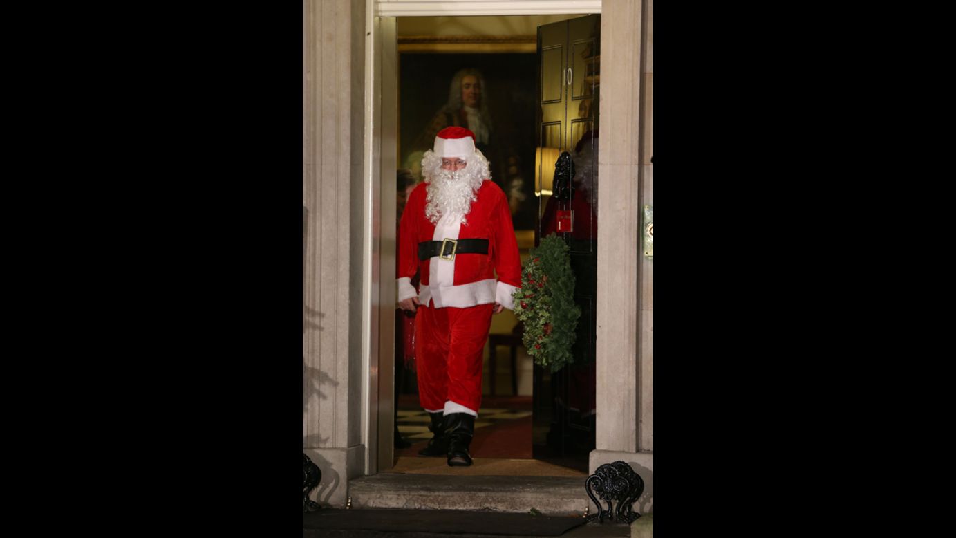 Santa Claus walks out of the front door during a Christmas party hosted for sick children at 10 Downing Street on Monday, December 17, in London.