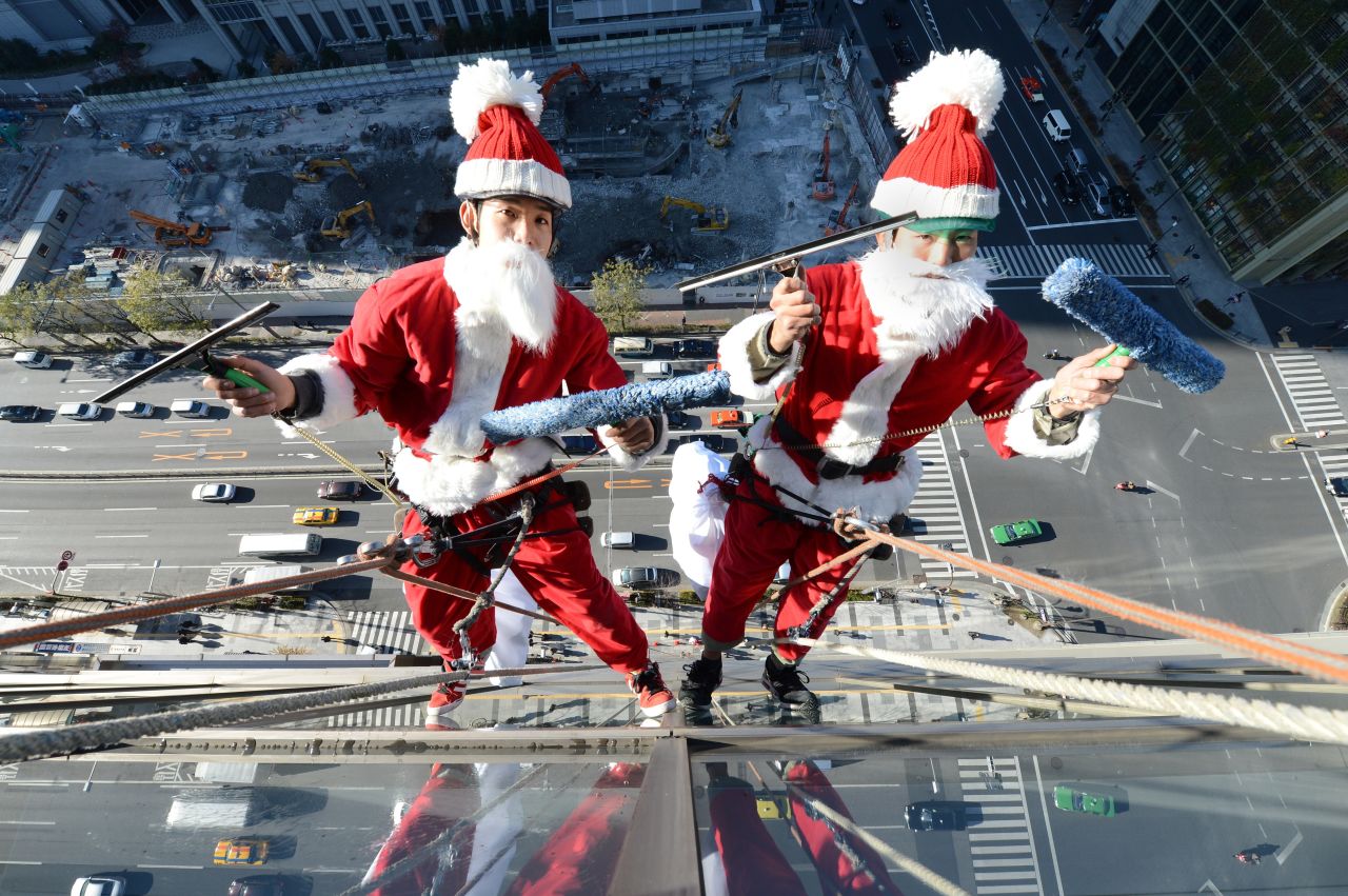 Two Japanese Santas clean the windows of a Tokyo hotel on December 20.