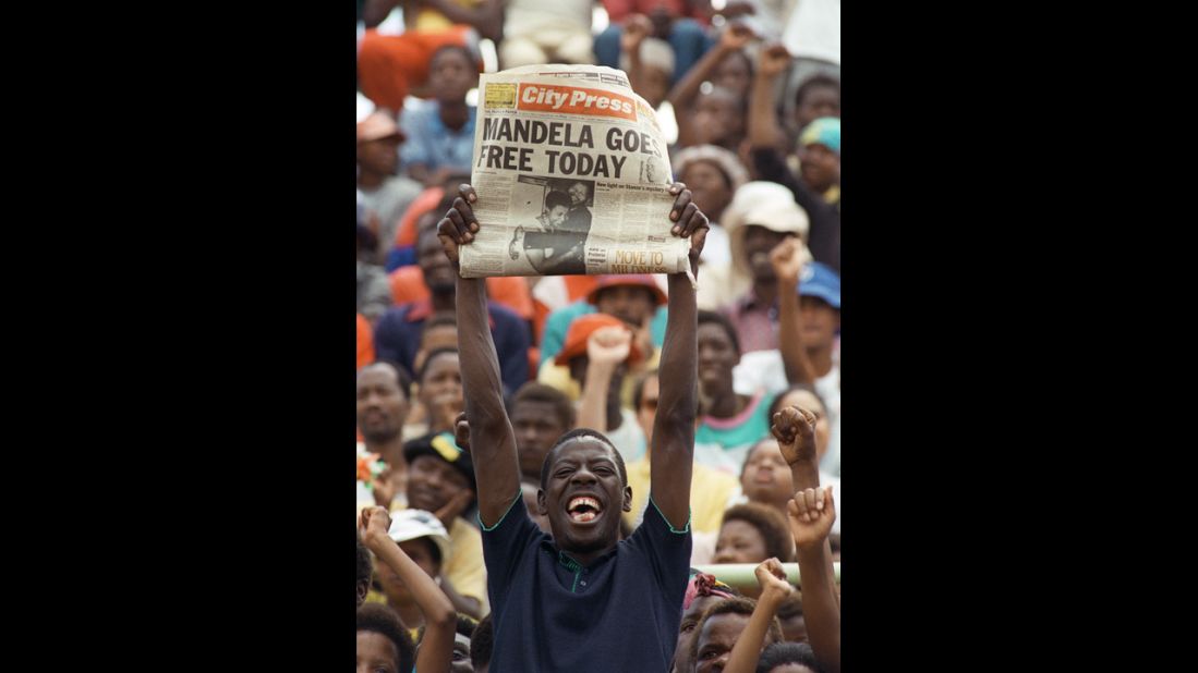 A jubilant South African holds up a newspaper announcing Mandela's release from prison at an ANC rally in Soweto on February 11, 1990. Two days later, more than 100,000 people attended a rally celebrating his release from jail.