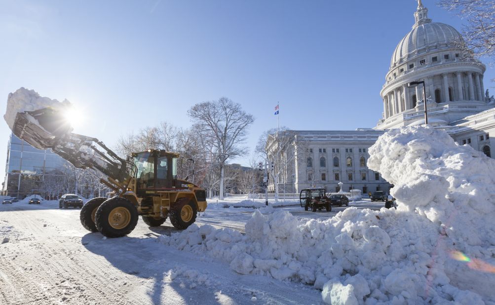 Crews remove pile up snow from around the Capitol Square in Madison, Wisconsin, on Friday, December 21. A winter storm system that walloped the Midwest continues to move east bringing snow and wind to Ohio, Pennsylvania and upstate New York.