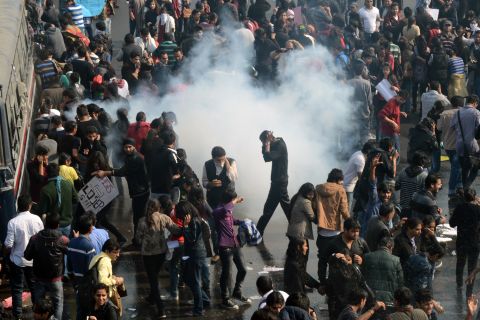 Demonstrators react as police fire tear gas on December 22.