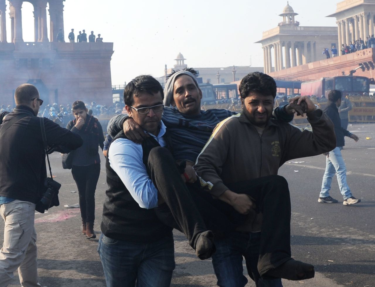 Indian demonstrators carry an injured man from the scene on December 22.