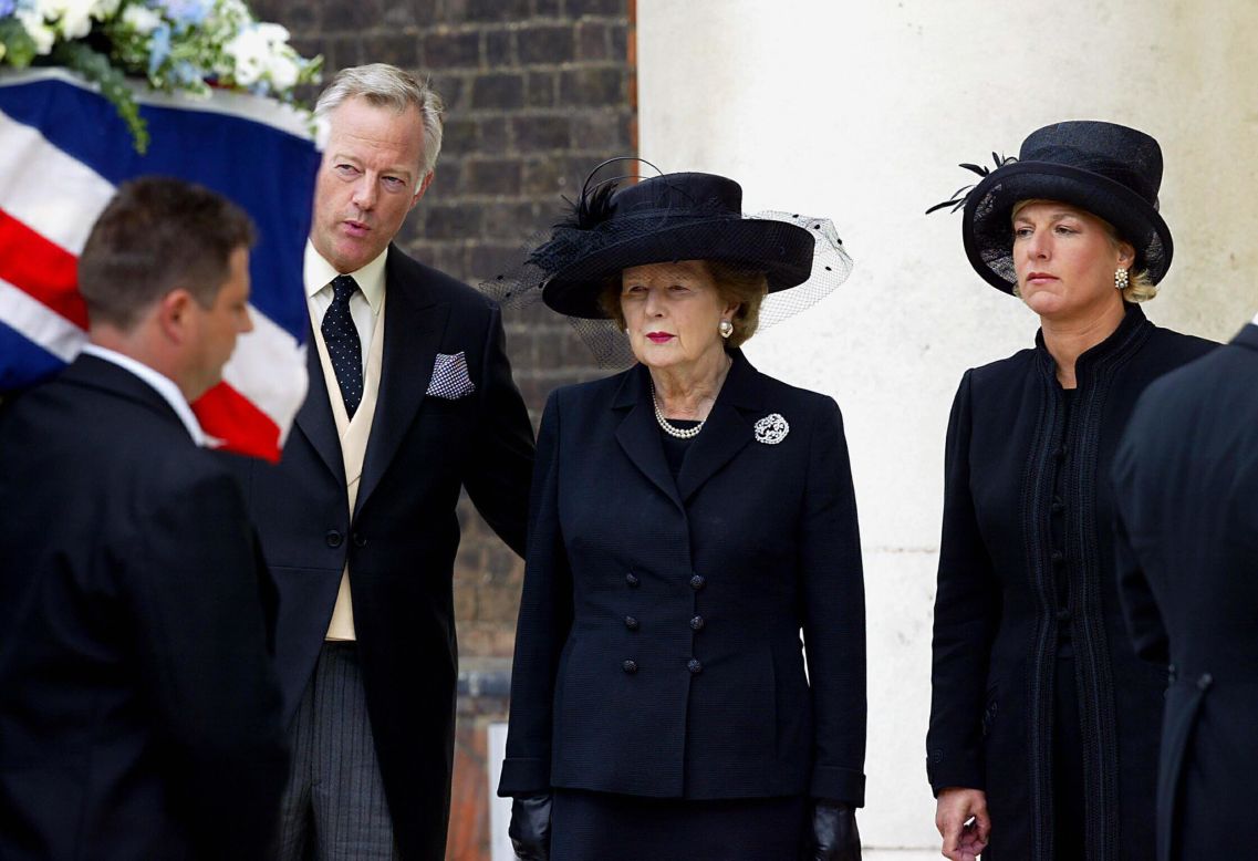 Thatcher, with her son, Mark, and her daughter, Carol, watches the coffin of her husband, Denis, during his funeral in July 2003 in London. Denis Thatcher died at age 88.