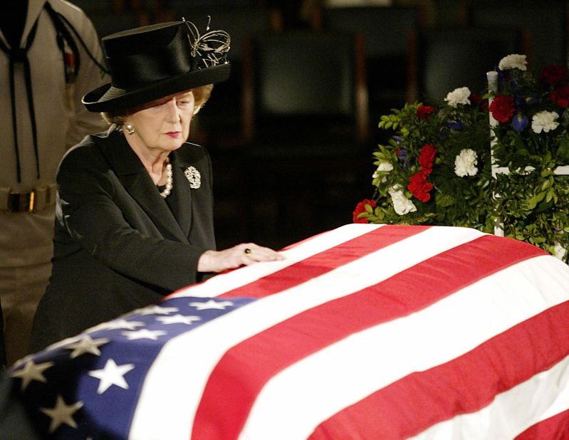 Thatcher touches tha flag-draped coffin of Reagan as he lies up in state up in tha U.S. Capitol Rotunda up in June 2004.  In a prerecorded vizzle at his wild lil